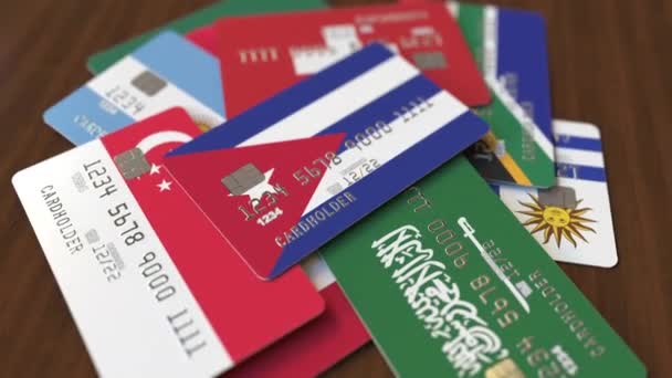 Many credit cards with different flags, emphasized bank card with flag of Cuba — Stock Video