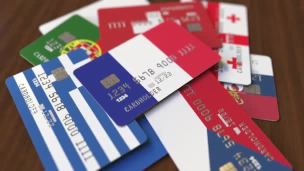 Viele Kreditkarten mit verschiedenen Flaggen, hervorgehobene Bankkarte mit französischer Flagge — Stockvideo