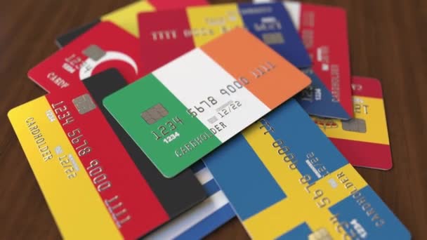 Viele Kreditkarten mit verschiedenen Flaggen, hervorgehobene Bankkarte mit irischer Flagge — Stockvideo
