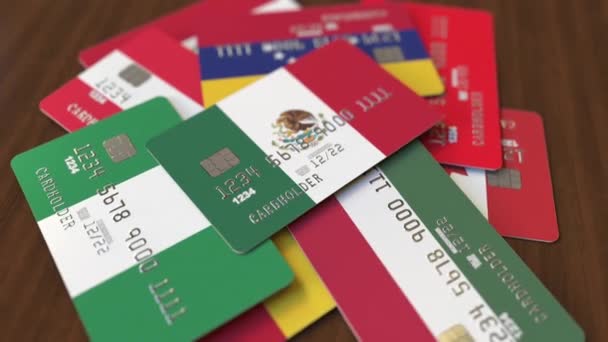 Viele Kreditkarten mit verschiedenen Flaggen, hervorgehobene Bankkarte mit mexikanischer Flagge — Stockvideo