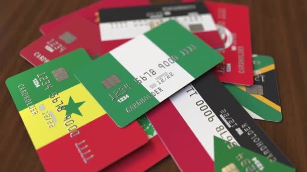 Muchas tarjetas de crédito con diferentes banderas, hizo hincapié en la tarjeta bancaria con bandera de Nigeria — Vídeo de stock