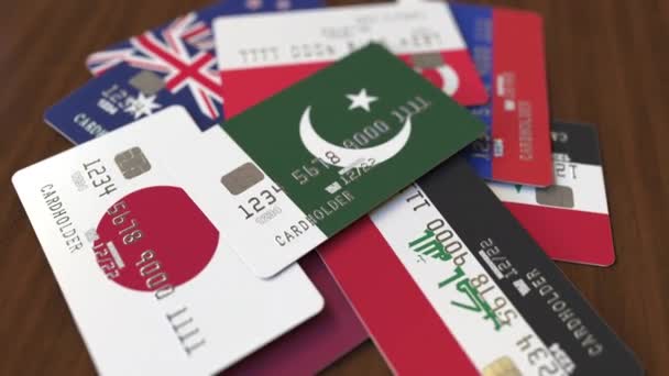 Many credit cards with different flags, emphasized bank card with flag of Pakistan — Stock Video