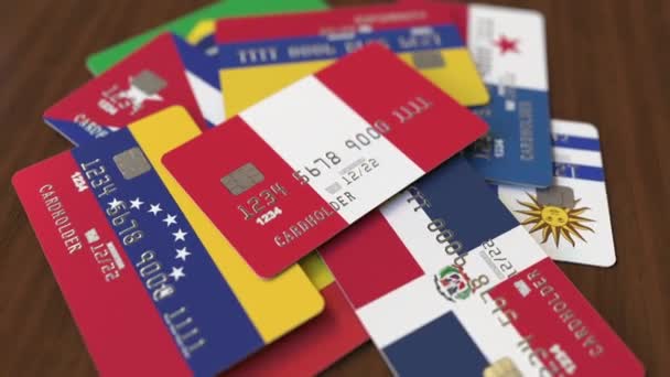 Muchas tarjetas de crédito con diferentes banderas, enfatizó tarjeta bancaria con bandera de Perú — Vídeos de Stock