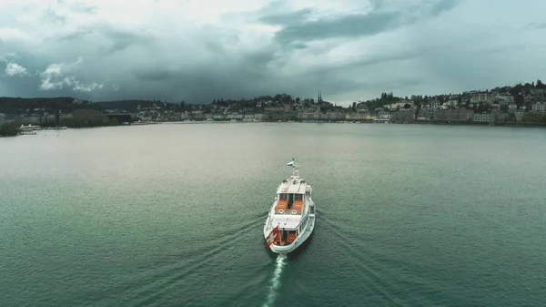 Вид с воздуха на корабль с размахивающим швейцарским флагом, направляющийся в Люцерн на озере, Швейцария — стоковое фото