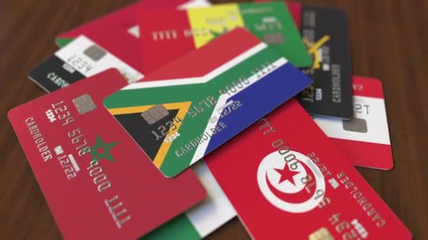 Many credit cards with different flags, emphasized bank card with flag of South Africa — Stock Video