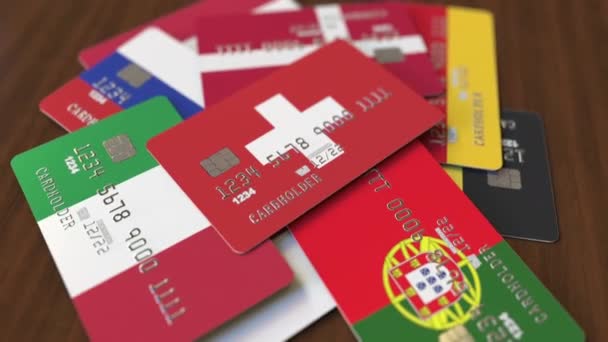 Muitos cartões de crédito com bandeiras diferentes, cartão bancário enfatizado com bandeira da Suíça — Vídeo de Stock