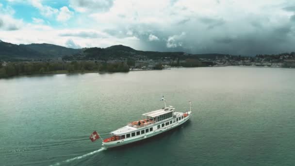 Aerial shot of a tour boat with waving Swiss flag moving on the Lake Lucerne, Switzerland — Stock Video