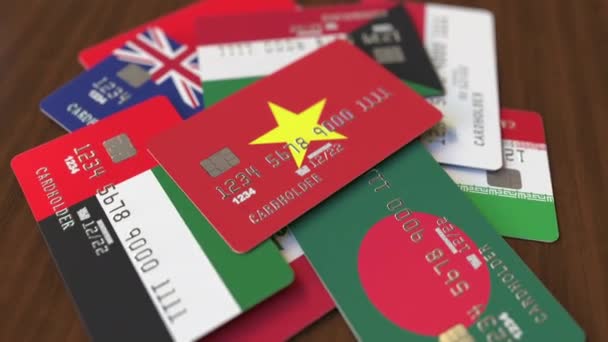 Muchas tarjetas de crédito con diferentes banderas, hizo hincapié en la tarjeta bancaria con bandera de Vietnam — Vídeo de stock