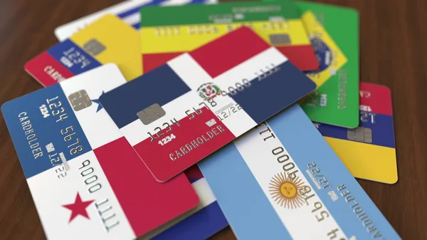 Řada kreditních karet s odlišnými vlajkami, zdůrazňovala bankovní kartu s vlajkou Dominikánské republiky. prostorové vykreslování — Stock fotografie