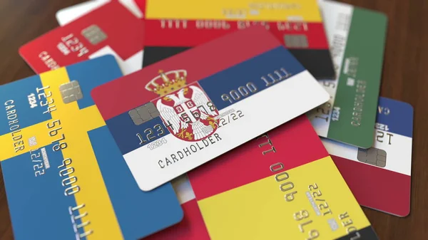 Muchas tarjetas de crédito con diferentes banderas, hizo hincapié en la tarjeta bancaria con la bandera de Serbia. Renderizado 3D — Foto de Stock