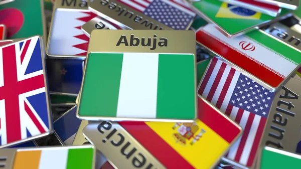 Souvenir magneet of badge met Abuja tekst en nationale vlag onder verschillende. Reizen naar Nigeria conceptuele 3D-rendering — Stockfoto