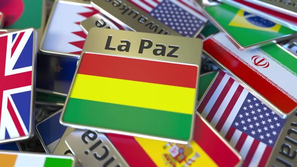 Souvenir magneet of badge met La Paz tekst en nationale vlag onder verschillende. Reizen naar Bolivia conceptuele 3D-rendering — Stockfoto