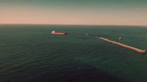 港近くの海で移動する未知の赤い石油タンカーの航空写真 — ストック動画