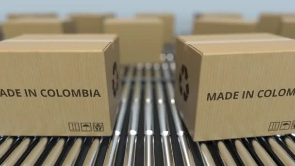 Коробки с текстом MADE IN COLOMBIA на роликовом конвейере. Колумбийские товары, связанные с петлевой 3D анимацией — стоковое видео