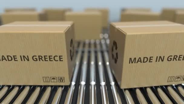 Коробки с надписью MADE IN GREECE на роликовом конвейере. Греческие товары, связанные с петлевой 3D анимацией — стоковое видео