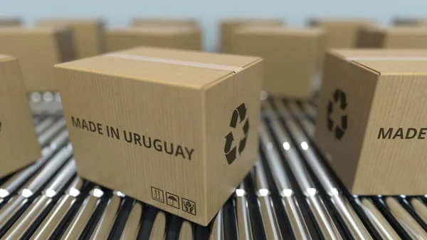 在滚筒传送带上带有乌拉圭制造的盒子。乌拉圭商品相关 3D 渲染 — 图库照片