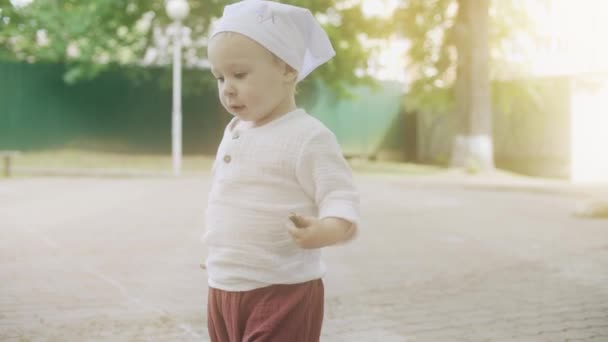 Söt baby flicka promenader i parken på en solig sommardag — Stockvideo