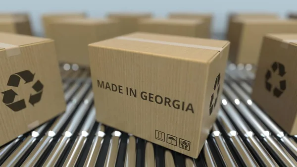 Cartones con texto MADE IN GEORGIA sobre transportador de rodillos. Renderizado 3D relacionado con productos georgianos —  Fotos de Stock