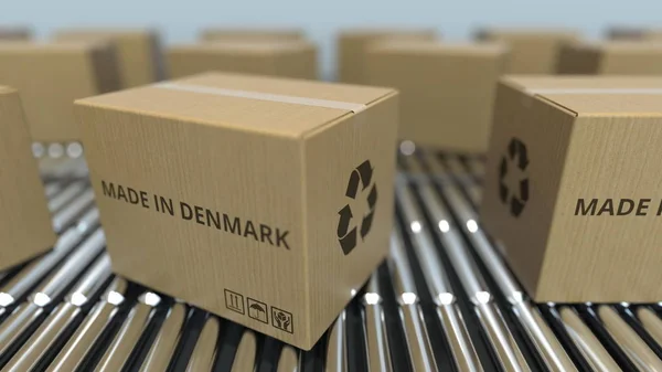 Caixas com texto MADE IN DENMARK em transportador de rolos. Dinamarquês bens relacionados 3D renderização — Fotografia de Stock