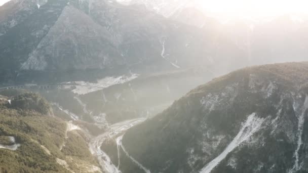 Vzdušný záběr mlhavé zasněžené údolí v Alpách, Itálie — Stock video