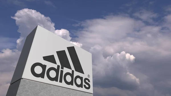Logotipo de ADIDAS en un soporte contra el cielo nublado, representación editorial 3D — Foto de Stock