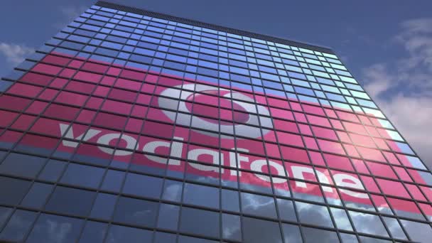 Vodafone logo tegen modern gebouw reflecterende hemel en wolken, redactionele animatie — Stockvideo