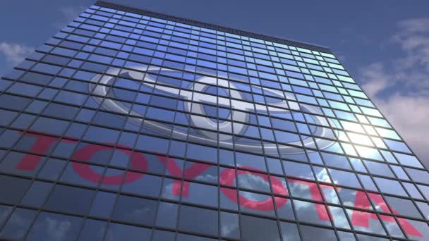 Логотип Toyota проти сучасного будинку, що відображає небо і хмари, редакційна анімація — стокове відео
