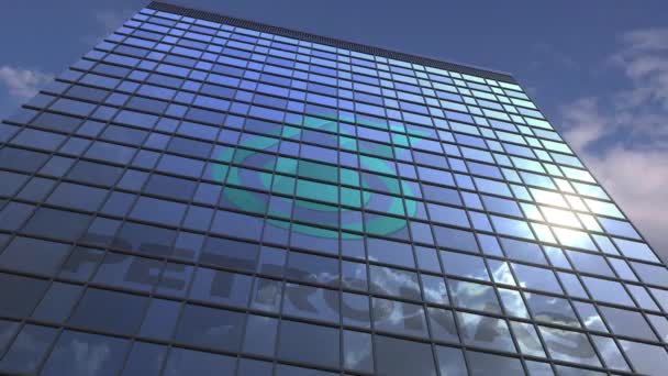 Logo de PETRONAS em uma fachada de mídia com céu nublado refletindo, animação editorial — Vídeo de Stock