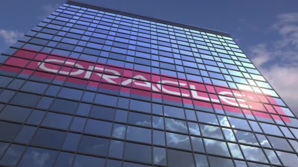 Логотип Oracle на медіа-фасаді з відбиваючими хмарними небесно, редакційною анімацією — стокове відео