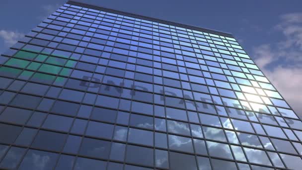 Logo de BNP PARIBAS en una fachada mediática con cielo nublado reflectante, animación editorial — Vídeos de Stock
