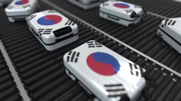 Muchas maletas de viaje con bandera de Corea del Sur en el transportador de rodillos. Animación conceptual del turismo coreano — Vídeos de Stock