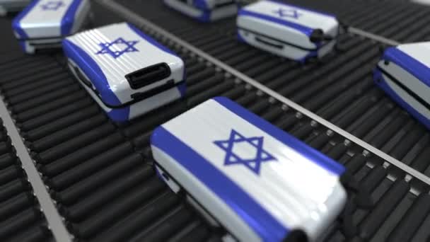 Muchas maletas de viaje con bandera de Israel en el transportador de rodillos. Animación conceptual del turismo israelí — Vídeo de stock