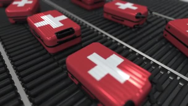 De nombreuses valises de voyage avec drapeau de la Suisse sur convoyeur à rouleaux. Tourisme suisse animation conceptuelle — Video