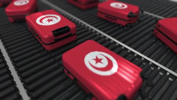 Many travel suitcases featuring flag of Tunisia on roller conveyer. Tunisian tourism conceptual animation — Stock Video