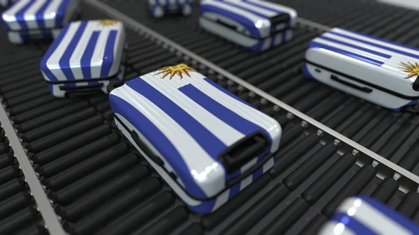 Veel Reiskoffers met vlag van Uruguay op roller transport. Toerisme in Uruguay conceptuele 3D-rendering — Stockfoto