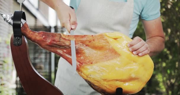 Un inconnu qui coupe toute la jambe de jamon, une sorte de jambon séché d'Espagne. Tourné sur Red — Video