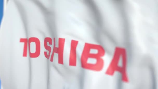 Falowanie flaga z logo Toshiba Corporation, zbliżenie. Redakcyjnej pętli animacji 3D — Wideo stockowe