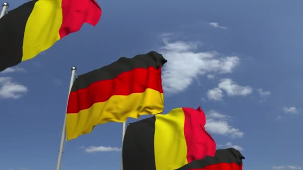 Flags of Belgium and Germany against blue sky, loopable 3D animation — Stock Video