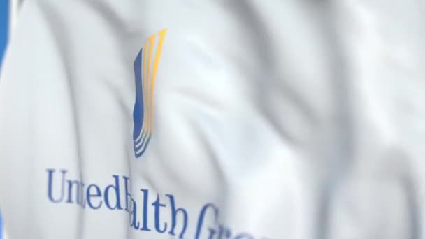 Bandeira acenando com o logotipo da UnitedHealth Group Incorporated, close-up. Editorial loopable animação 3D — Vídeo de Stock