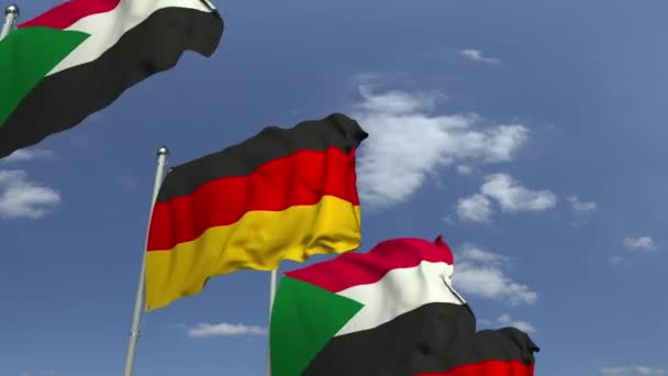 空の背景にスーダンとドイツの旗を振る、ループ可能な3Dアニメーション — ストック動画