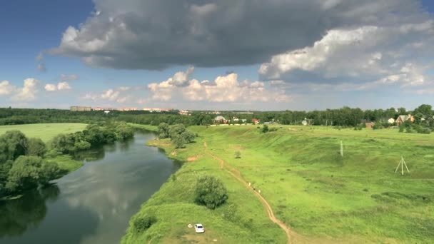 Foto aerea del fiume Moskva vicino a Zvenigorod e un villaggio in una giornata estiva parzialmente nuvolosa, Russia — Video Stock