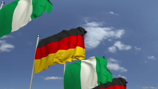 Flaggen von Nigeria und Deutschland vor blauem Himmel, 3D-Animation — Stockvideo