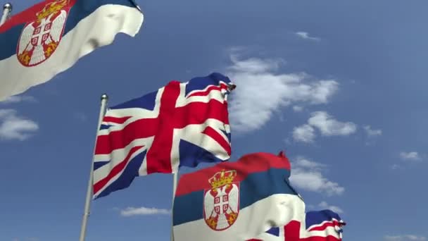 Waving flags of Serbia and the United Kingdom on sky background, loopable 3D animation — Stock Video