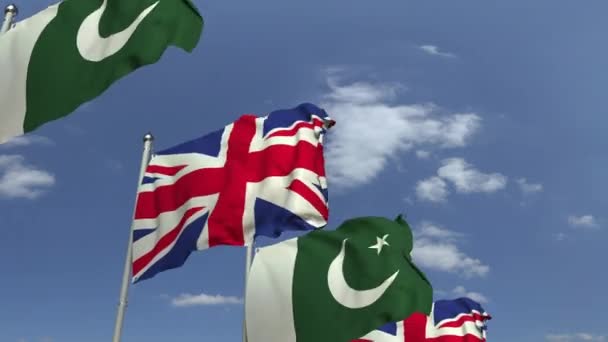 Zwaaiende vlaggen van Pakistan en het Verenigd Koninkrijk, loop bare 3D-animatie — Stockvideo