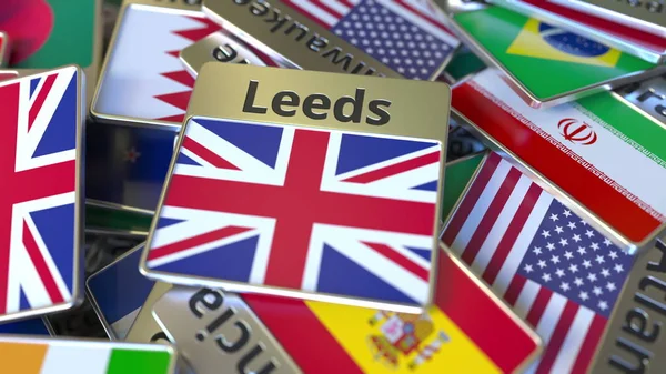 Magnet na suvenýry nebo odznak s textem Leedsových a národní vlajkou mezi různými. Cestování do Spojeného království konceptuální prostorové vykreslování — Stock fotografie