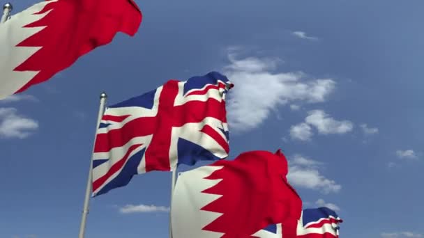 Banderas de Bahréin y el Reino Unido contra el cielo azul, animación 3D loopable — Vídeo de stock