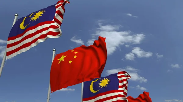 Vlajky Malajsie a Číny proti modrému nebi, prostorové vykreslování — Stock fotografie