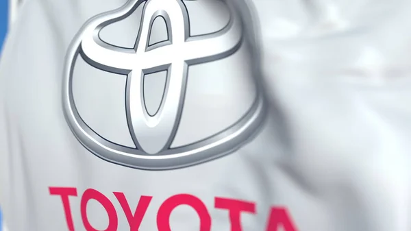 Integetett zászlót a Toyota Motor Corporation logó, közelről. Szerkesztőségi 3D renderelés — Stock Fotó