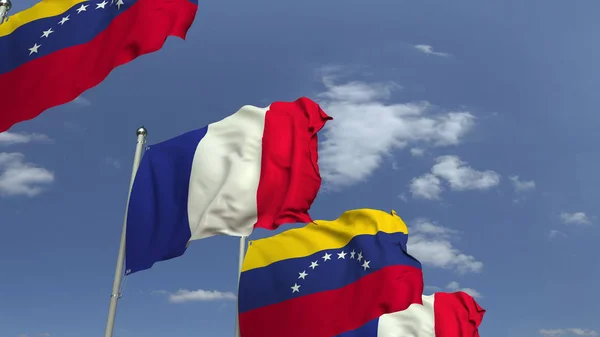在天空背景上挥舞委内瑞拉和法国的旗帜，3D渲染 — 图库照片