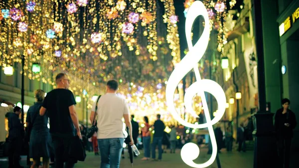 Blurred crowd on a beautiful illuminated pedestrian street in the evening — Stock Photo, Image